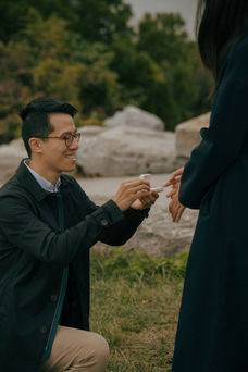 surprise proposal on the Governors Island waterfront promenade at sunset