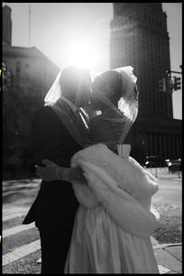 bride and groom kissing in sunlight outside manhattan courthouse nyc elopement black and white candid photographer nyc