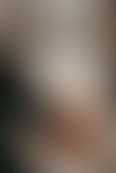 Romantic couple photoshoot by window Rockefeller Tree Christmas in NYC holding hands smiling with engagement ring