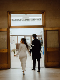 couple walking hand in hand toward marriage licenses records door brooklyn city hall nyc