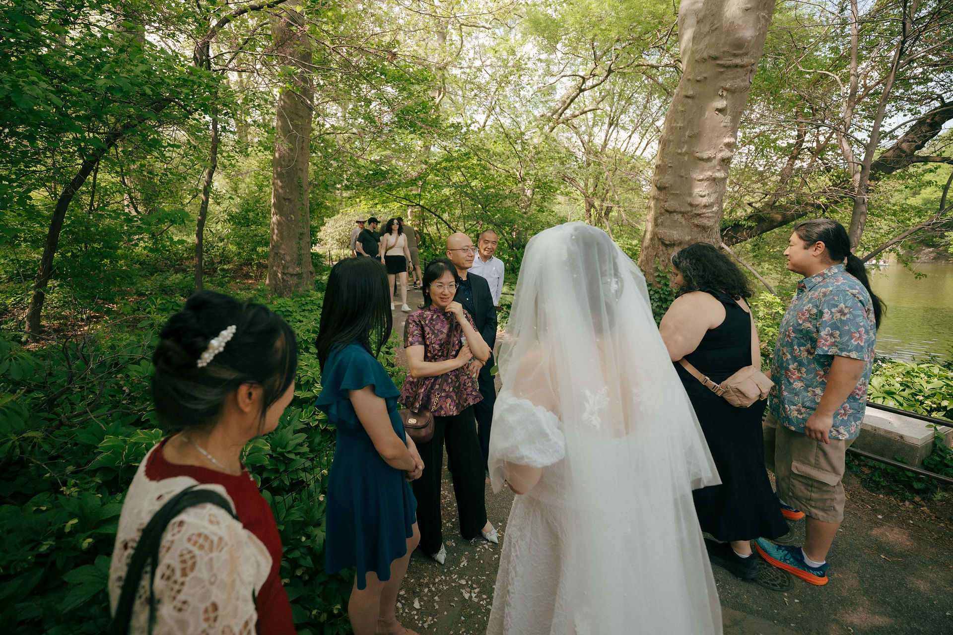 Bride in white dress with wedding guests at Ladies Pavilion, Central Park during summer New York elopement photography