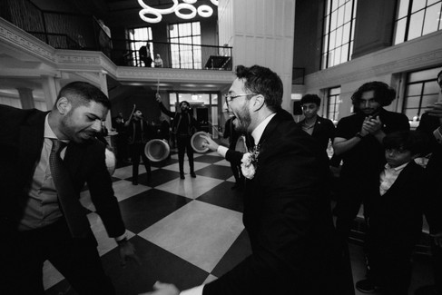 Black and white candid wedding photography of groom dancing with friends at NYC reception by documentary wedding photographer