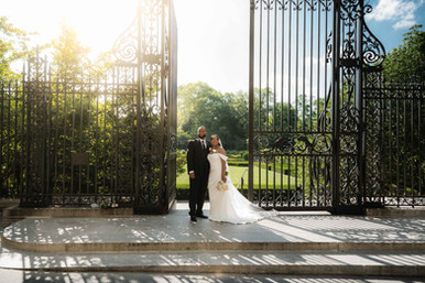 Cinematic romantic photo of a couple entering through the Vanderbilt Gate for their Conservatory Garden Central Park wedding, All The Feels