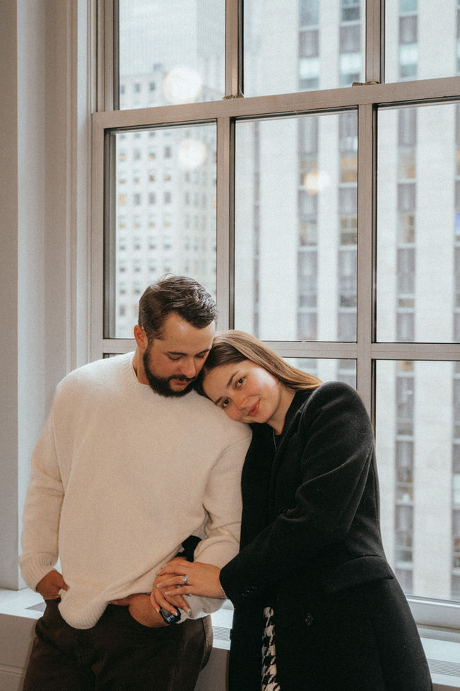 Couple hug on NYC rooftop during marriage proposal photoshoot in New York, cityscape backdrop, relaxed and content, romantic photoshoot engagement at 620 loft and garden