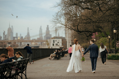 Newlyweds walking along Brooklyn Heights Promenade with NYC skyline view after Brooklyn City Hall elopement