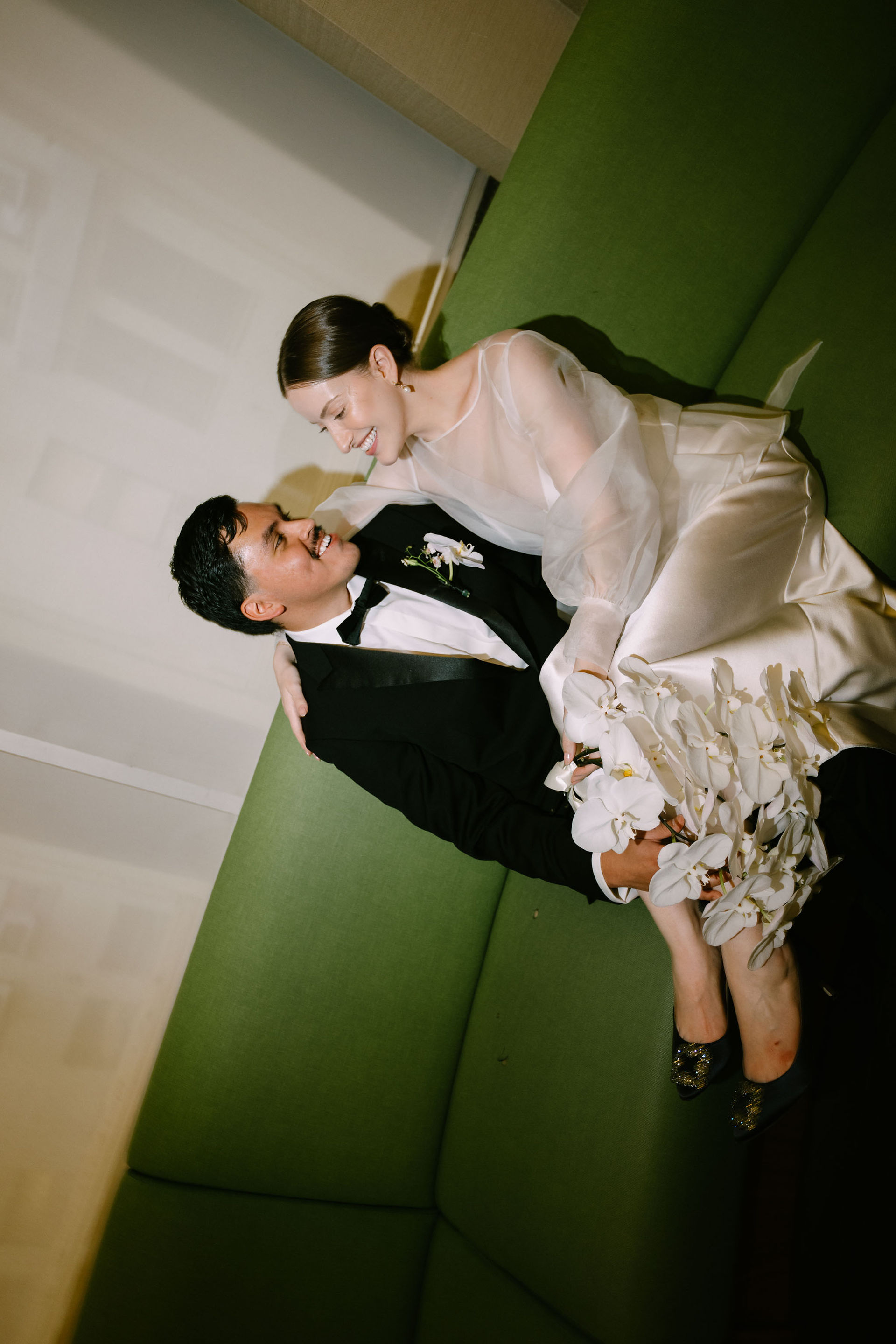 romantic 35mm film shot of newlyweds on the green Marriage Bureau couches, NYC elopement, All The Feels