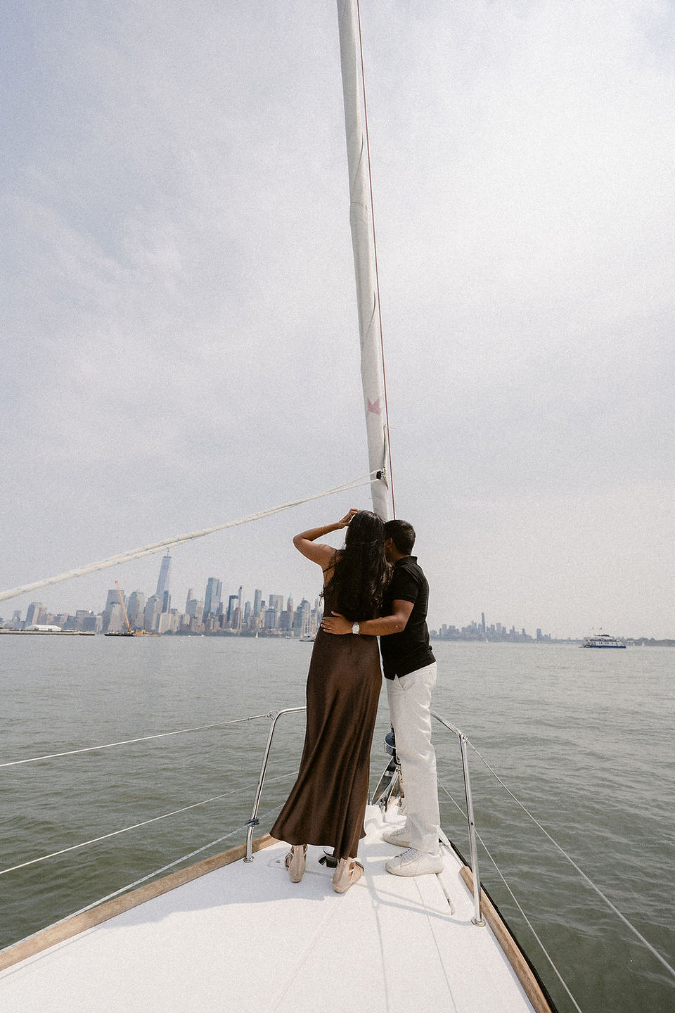 sailboat proposal nyc with the Statue of Liberty and Manhattan views behind the couple 