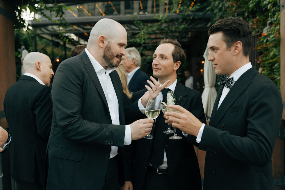 Groom giving a toast surrounded by friends at Brooklyn reception