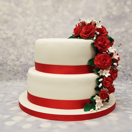 Two-tiered white cake witha cascade of red roses and ribbon, Anniversary celebration
