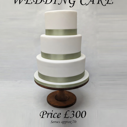 3 tier stacked fondant iced round cake on white board. A sage green around base of each cake and board. Simple wedding cake ready for decorations to be added