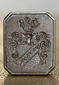 Dark metal seal stamp with salamanders in the coat of arms.