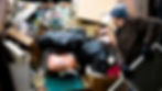 Man looking into a dumpster overflowing with trash