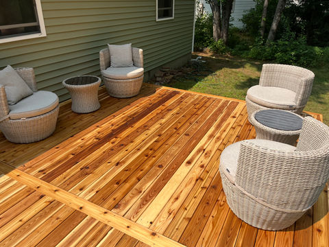 Wooden deck with outdoor wicker chairs and tables