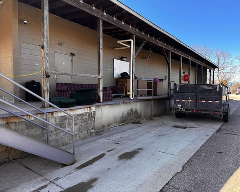 Industrial loading dock with metal stairs, trailer, and STOP sign
