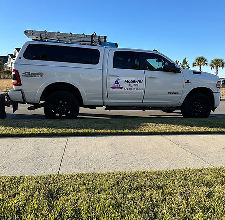 White pickup truck with camper shell and ladder