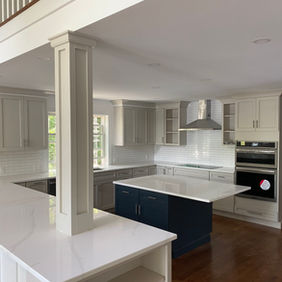 Modern kitchen with white cabinets and dark blue island