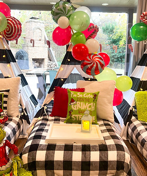 Grinch-themed teepee sleepover with green and red decor, Christmas lights, and festive Whoville touches