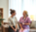 1 young women and 1 smiling nurse (not dressed too medically) at home in living room - tal