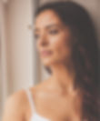 Woman gazing out window in quiet contemplation, seeking inner healing and soul-level change.
