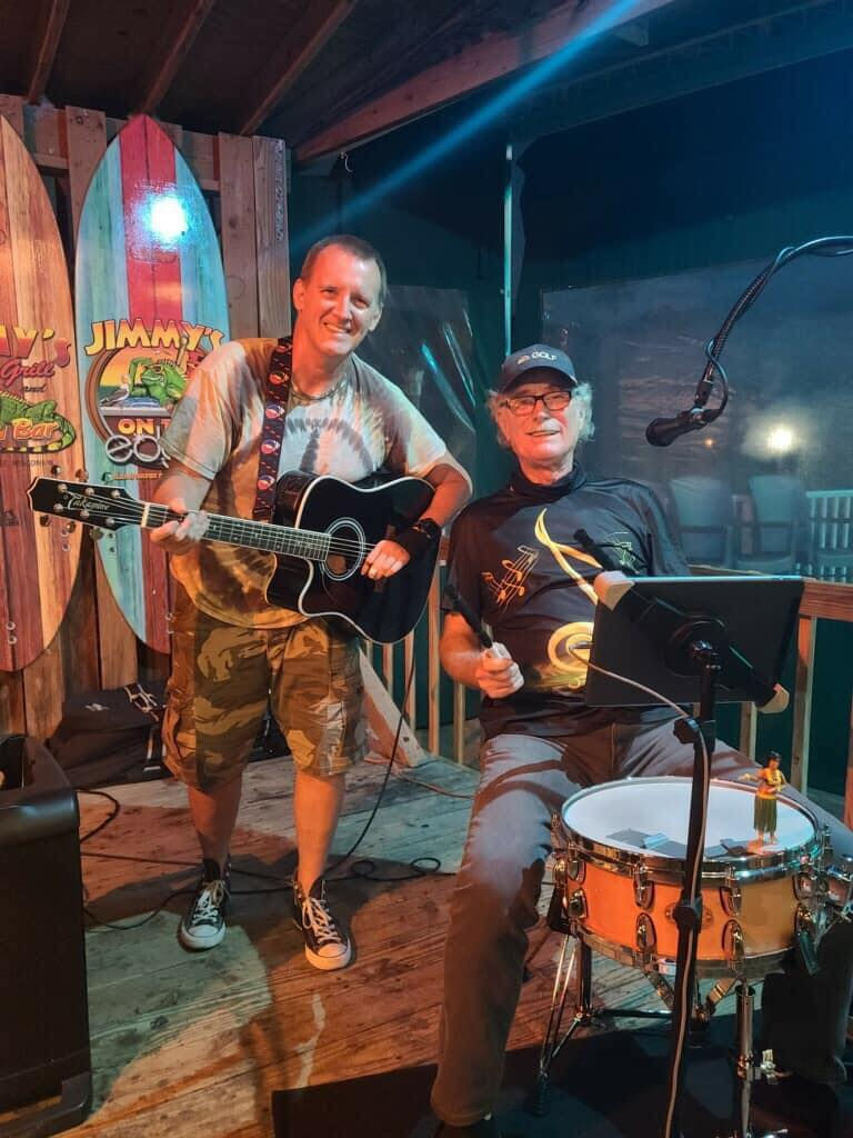 Vini drums while Toney Hall strums, in their Florida-based group The Hula Hula Boys, via Vini's Facebook page