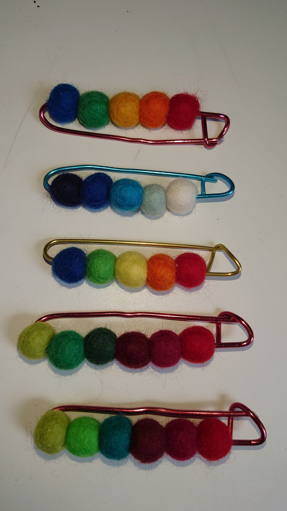 Range of coloured wool felt balls on coloured kilt pin