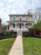 Finished exterior painting on a two-story tan house.