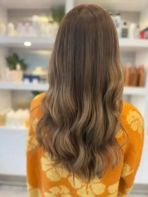 Back view of bronde hair with blended blonde tones and loose waves.