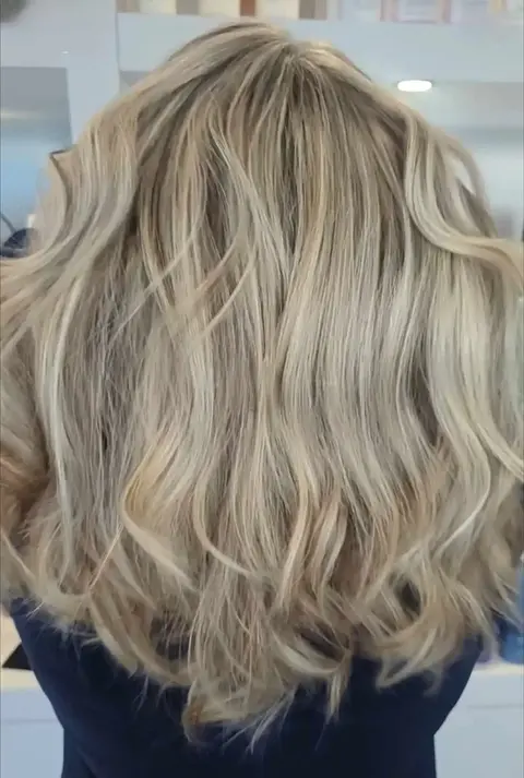 Medium-length wavy hair with soft grey blending and subtle highlights
