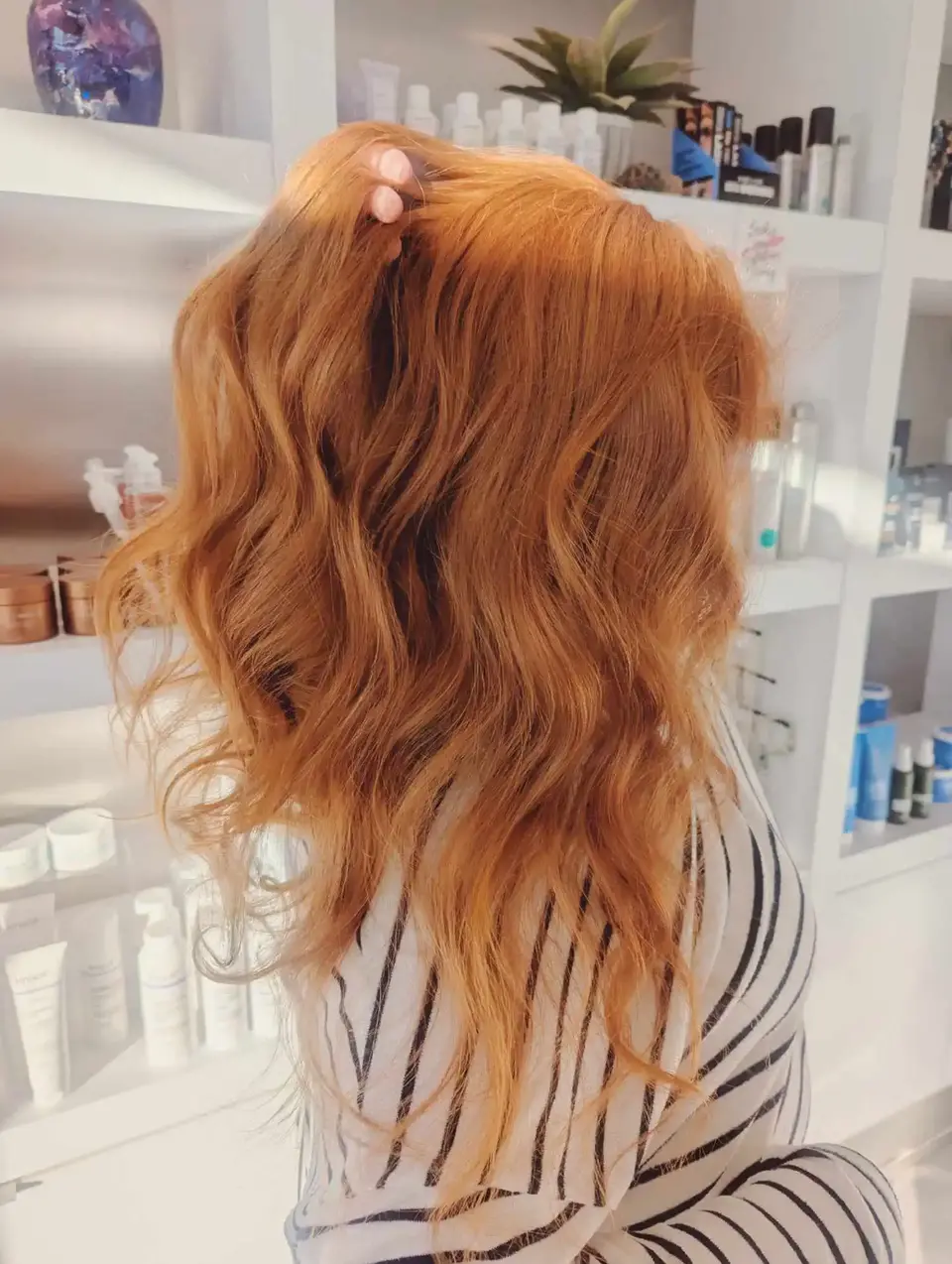Golden copper wavy hair in side view with soft curls