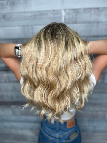 Sun-kissed blonde hair styled in natural beach waves.