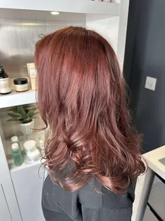 Side view of cherry cola brunette hair with soft curls and red undertones