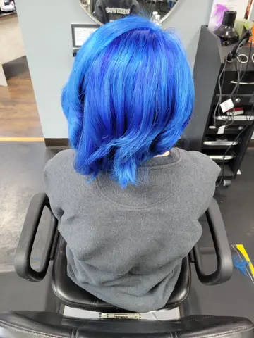 Side, top, and back views of a vibrant electric blue bob with soft volume and shine.