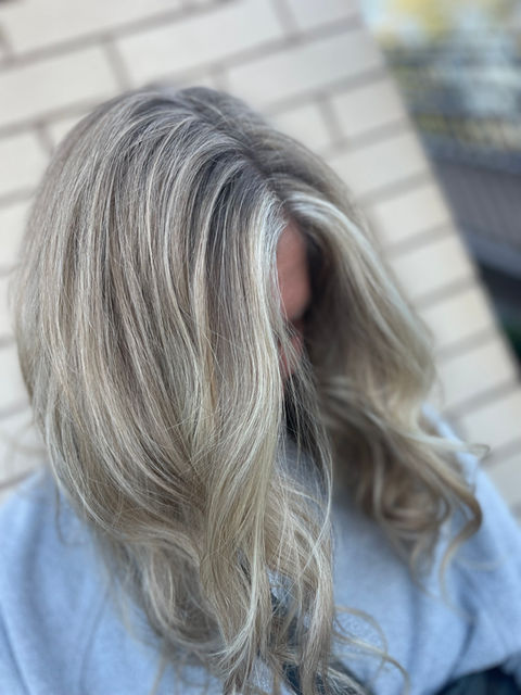Close-up of soft silver blonde hair styled in loose waves for a natural, dimensional look.
