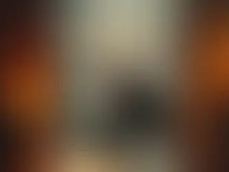 Silhouetted person sits pensively by a window in a dimly lit room, with an urban nightscape visible outside. Warm tones create a contemplative mood.