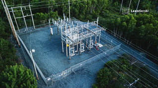 Autonomous drone conducting perimeter security patrol over an electrical transmission substation at night, providing aerial surveillance of the fence line and surrounding terrain that fixed cameras cannot reach