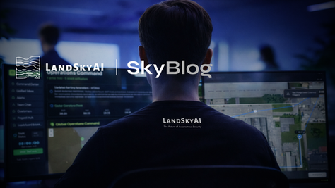Back of man at glowing security monitors with LANDSKYAI SkyBlog logo and map interface in a dark blue control room.