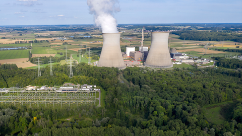 Aerial view of a power plant with cooling towers and electrical substation, an example of critical energy infrastructure protected by autonomous drone security.