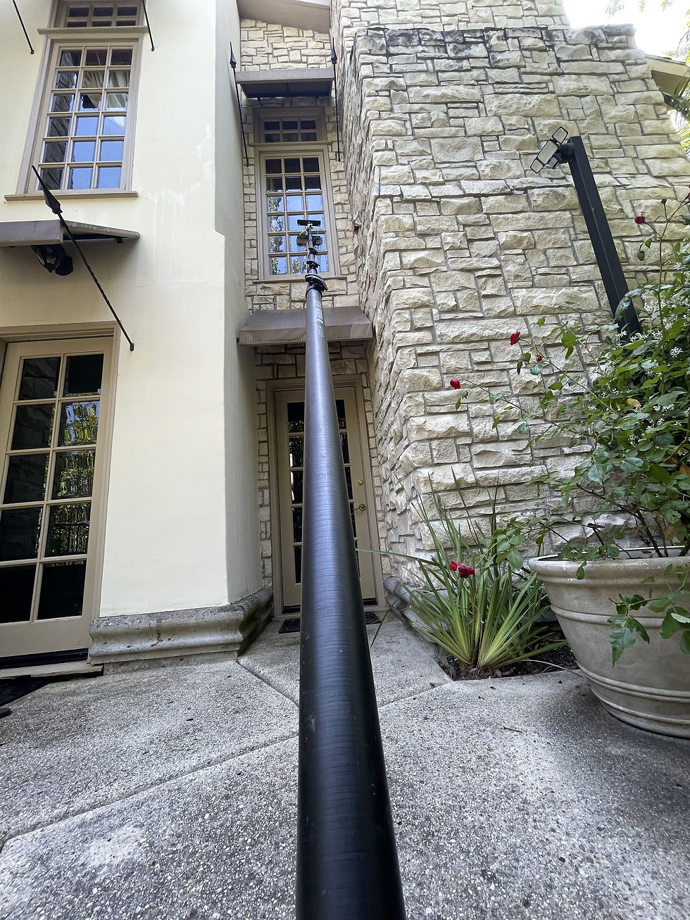 Water-fed pole reaching second-story windows on a stone home