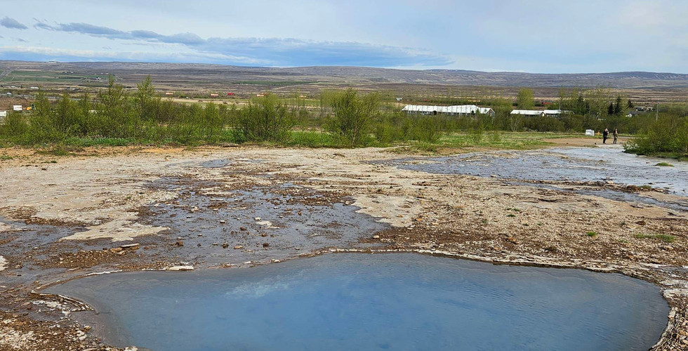Admiring the mesmerizing blue-green hues of the geysir pool.