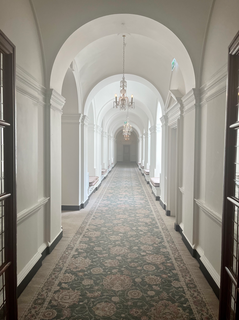 long white corridor with arched ceiling panels and patterned rug