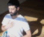 יואב יושב בעיניים עצומות ומניח יד על החזה בזמן מדיטציה