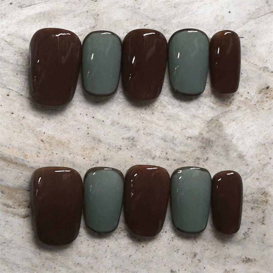 Mocha Sage press-on nails by M Press Beauty featuring glossy chocolate brown and muted sage green alternating nails in a short, rounded-square shape.