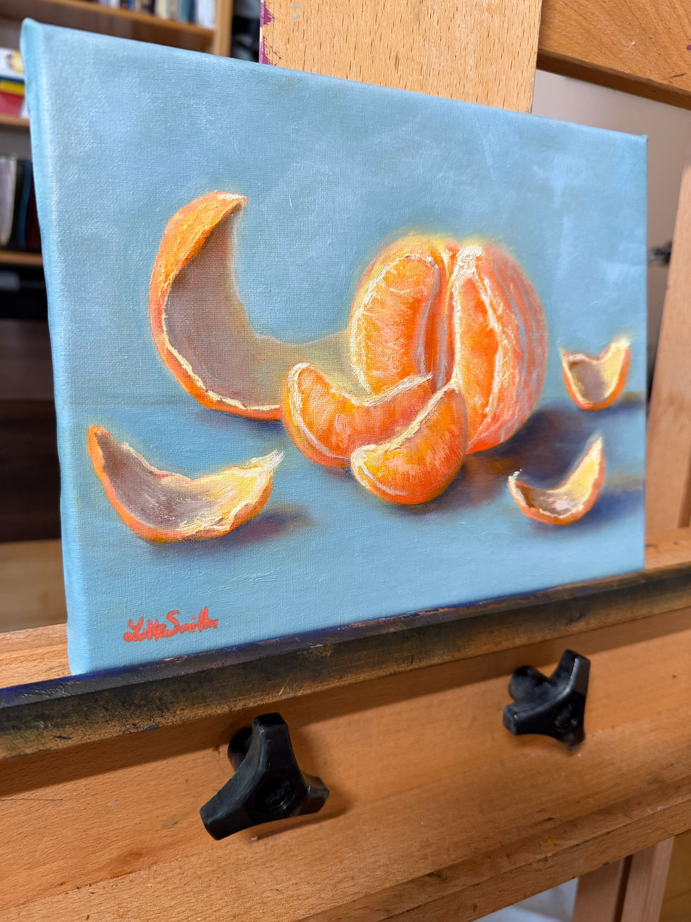 A still life oil painting of a glowing peeled orange in segments.