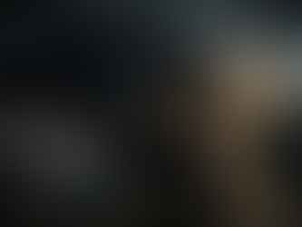 Eine junge Frau sitzt erschöpft auf einem Bett, den Kopf in den Händen vergraben. Hinter ihr erhebt sich ein dunkler, bedrohlicher Schatten mit leuchtenden Augen, der die innere Selbstkritik symbolisiert.