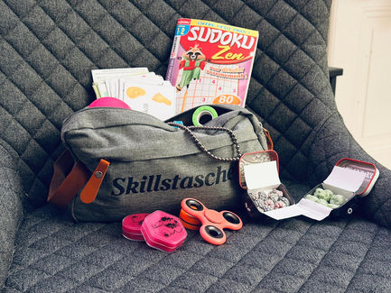 Skillstasche mit vielen verschieden gadgets wie Fidgetsspinner, Magnetkette, Sudoku, Knete