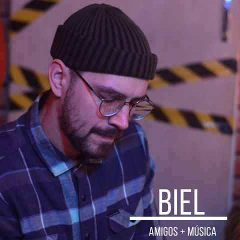 Retrato de Biel, produtor musical, usando touca e tocando um instrumento
