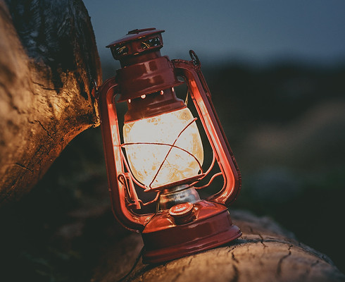 Kerosene lamp balanced on rock with dark sky background. Image by guilherme-stecanella-Dli