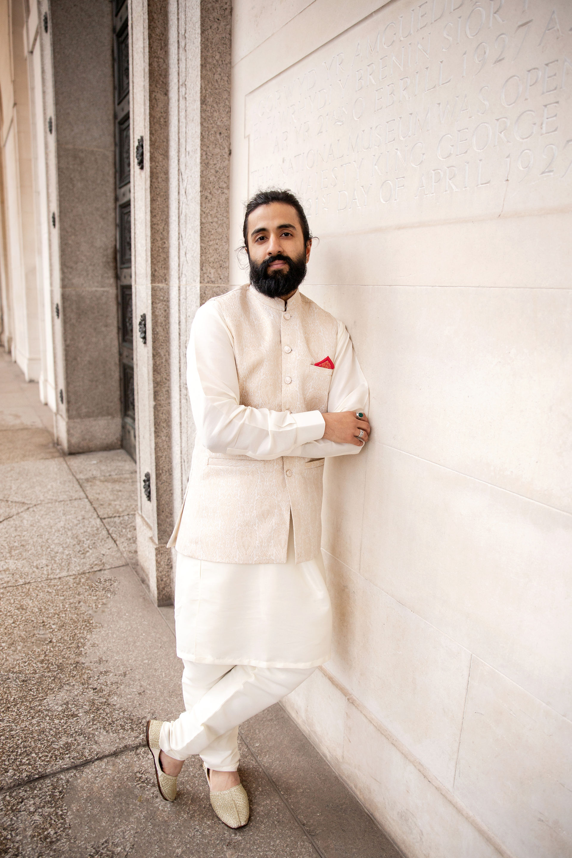 Groom posing leaning on the wall