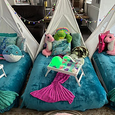 Close up photograph of one of three teepees with a seahorse and multiple sea turtles.