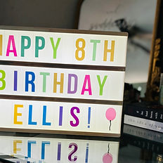 Light up sign that says "Happy 8th Birthday Ellis" in multi color letters